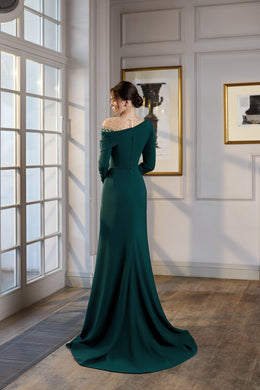 Teal evening dress showing a fitted back, sheer beaded upper panel, long sleeves, and a flowing floor-length train
