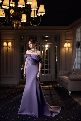 Lavender evening dress with an off-the-shoulder draped neckline, fitted mermaid silhouette, and train