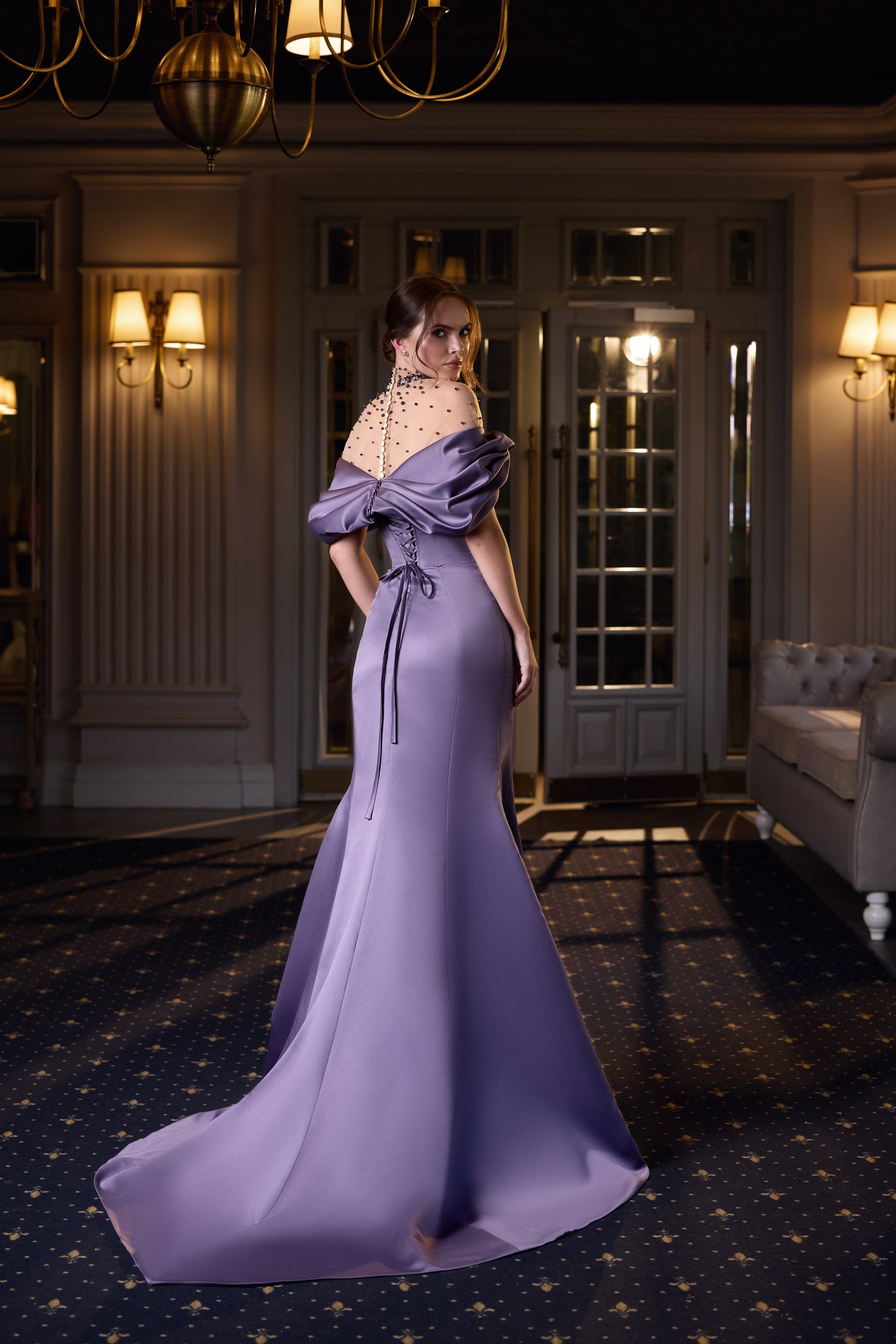 Lavender evening dress showing a draped off-the-shoulder back and long flowing train