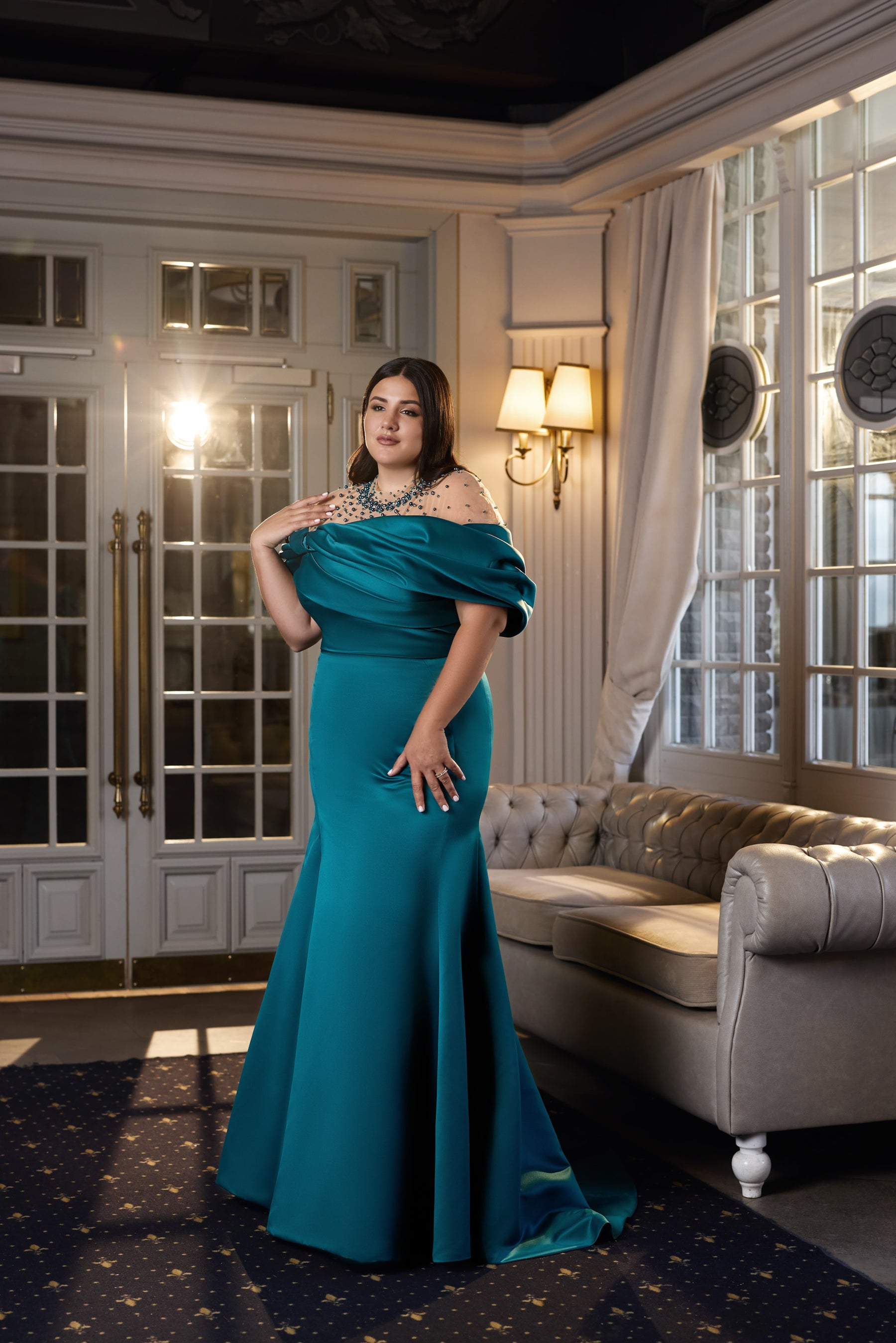 Teal evening dress with a draped off-the-shoulder neckline, embellished sheer yoke, and floor-length skirt