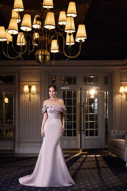 Pale pink evening dress with a draped off-the-shoulder neckline, sheer embellished yoke, and mermaid skirt