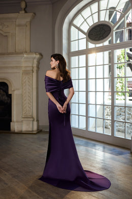 Deep purple evening dress with a draped off-shoulder back, fitted skirt, and long trailing hem