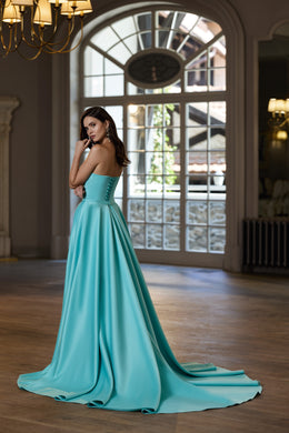 Turquoise evening dress with a lace-up back, full pleated skirt, and sweeping floor-length train