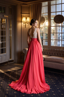 Red evening dress with a low open back, sparkling beaded bodice, flowing skirt, and a long pooled train