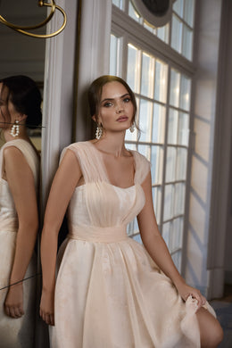 Ivory evening dress with a square neckline, sheer cap sleeves, fitted waist, and full skirt