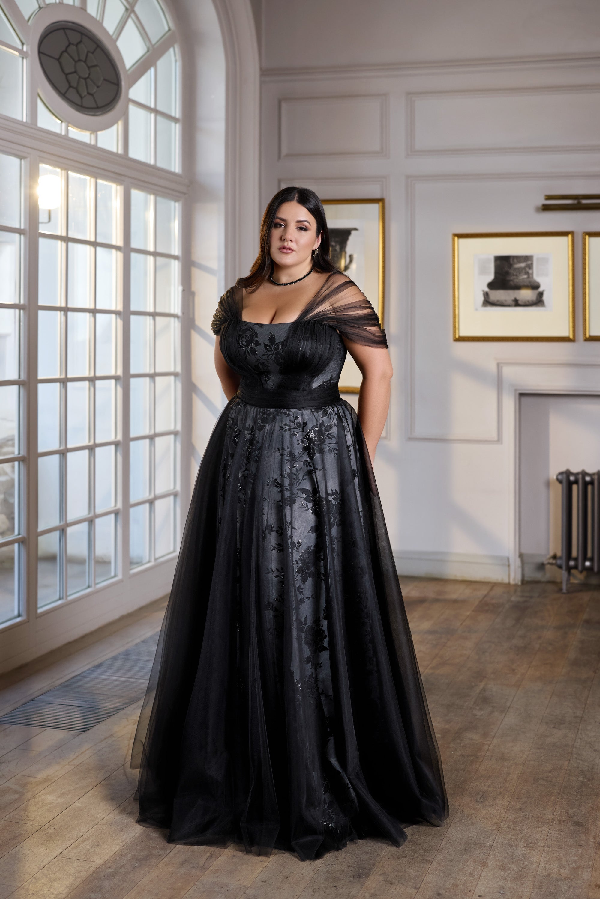 Black evening dress with an off-the-shoulder neckline, fitted bodice, and long full skirt
