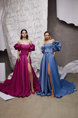 Magenta and blue satin evening dresses with off-shoulder puff sleeves, thigh-high slits, and long trains
