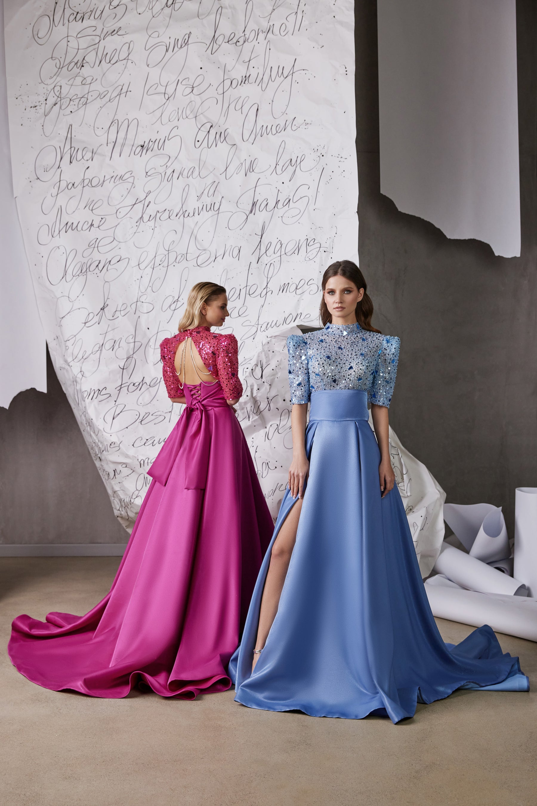 Blue evening dress with a jeweled bodice, high slit, and long A-line skirt beside the pink version shown from behind