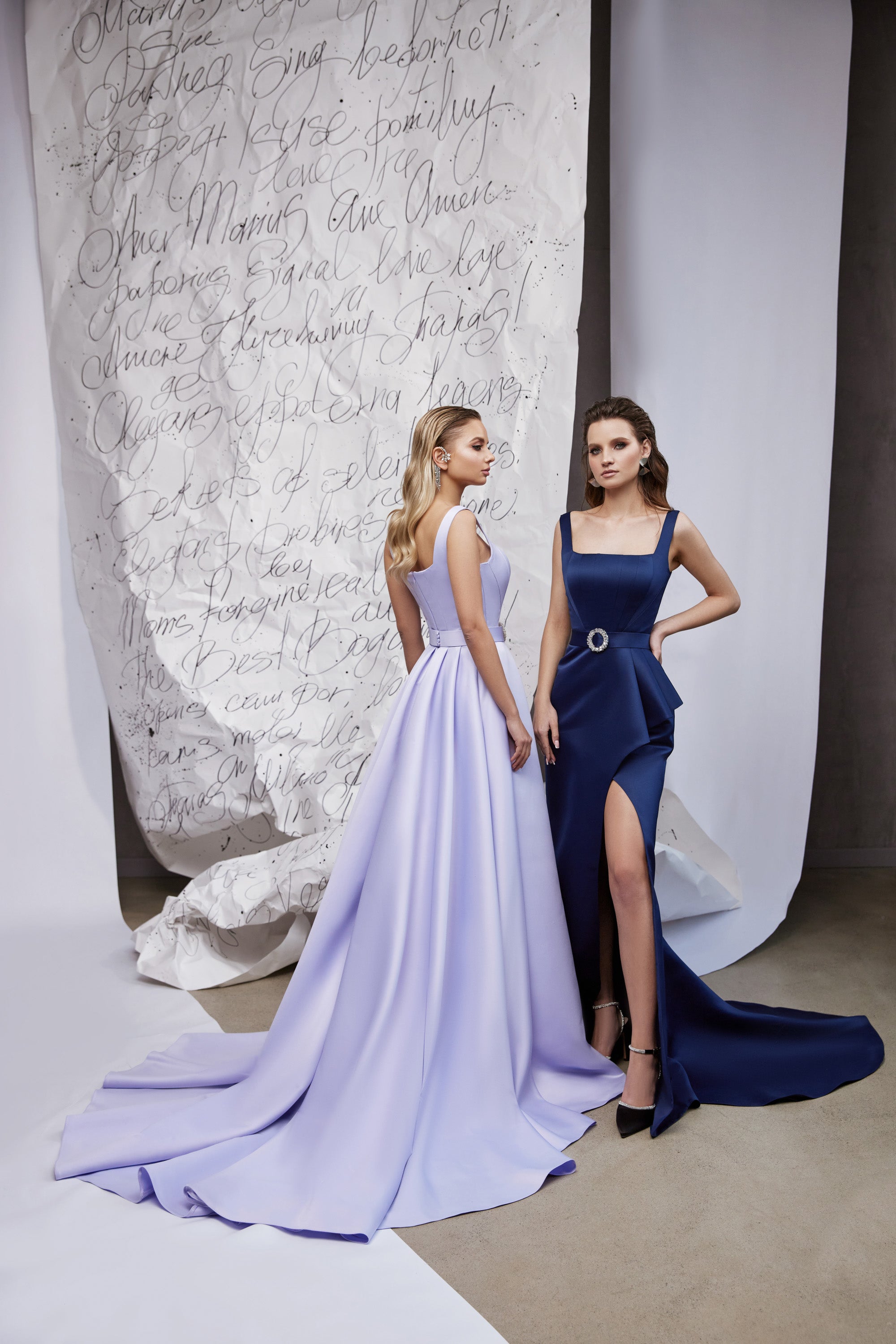 Lavender evening dress shown from the back with wide shoulder straps, a full flowing skirt, and long train