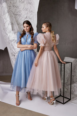 Blush pink glitter tulle evening dress with puff sleeves, a gathered waist, and a tea-length skirt shown from behind