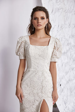 White lace evening dress with a square neckline, puff sleeves, fitted pencil silhouette, and front slit