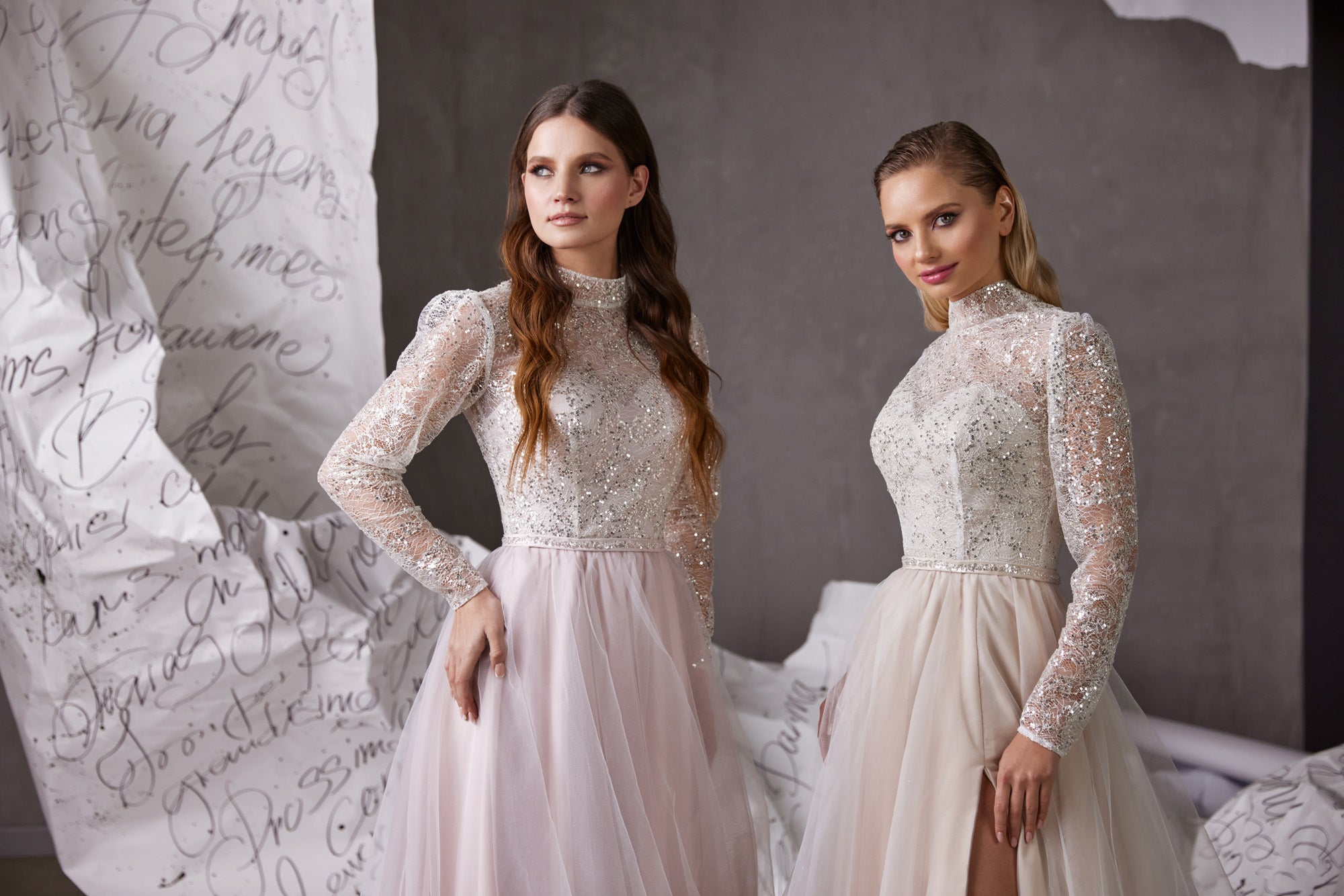 Close-up of pale pink and ivory evening dresses with sparkling bodices, sheer embellished sleeves, and high necklines