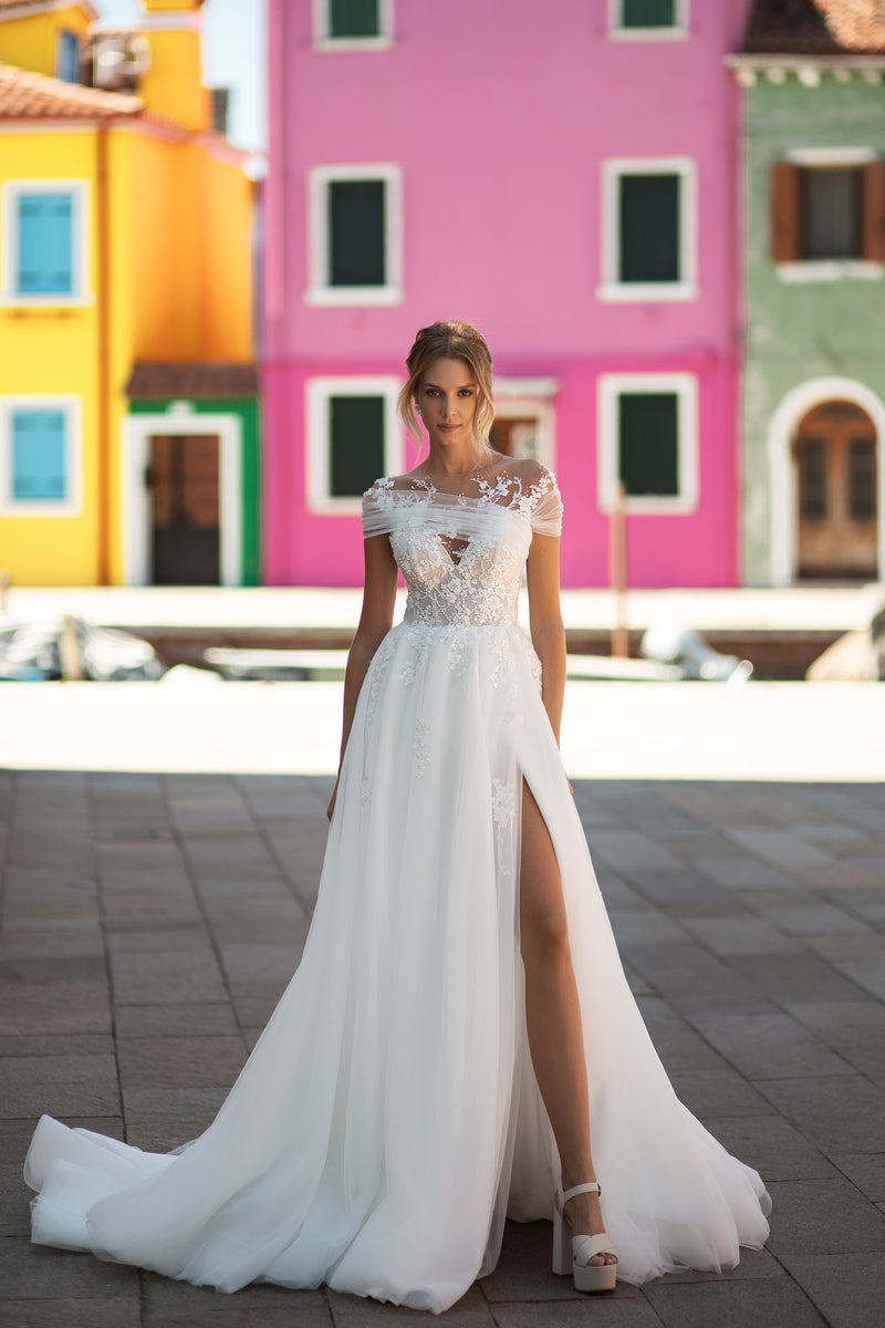 Ivory A-line wedding dress with an illusion lace neckline, embellished bodice, thigh-high slit, and court train