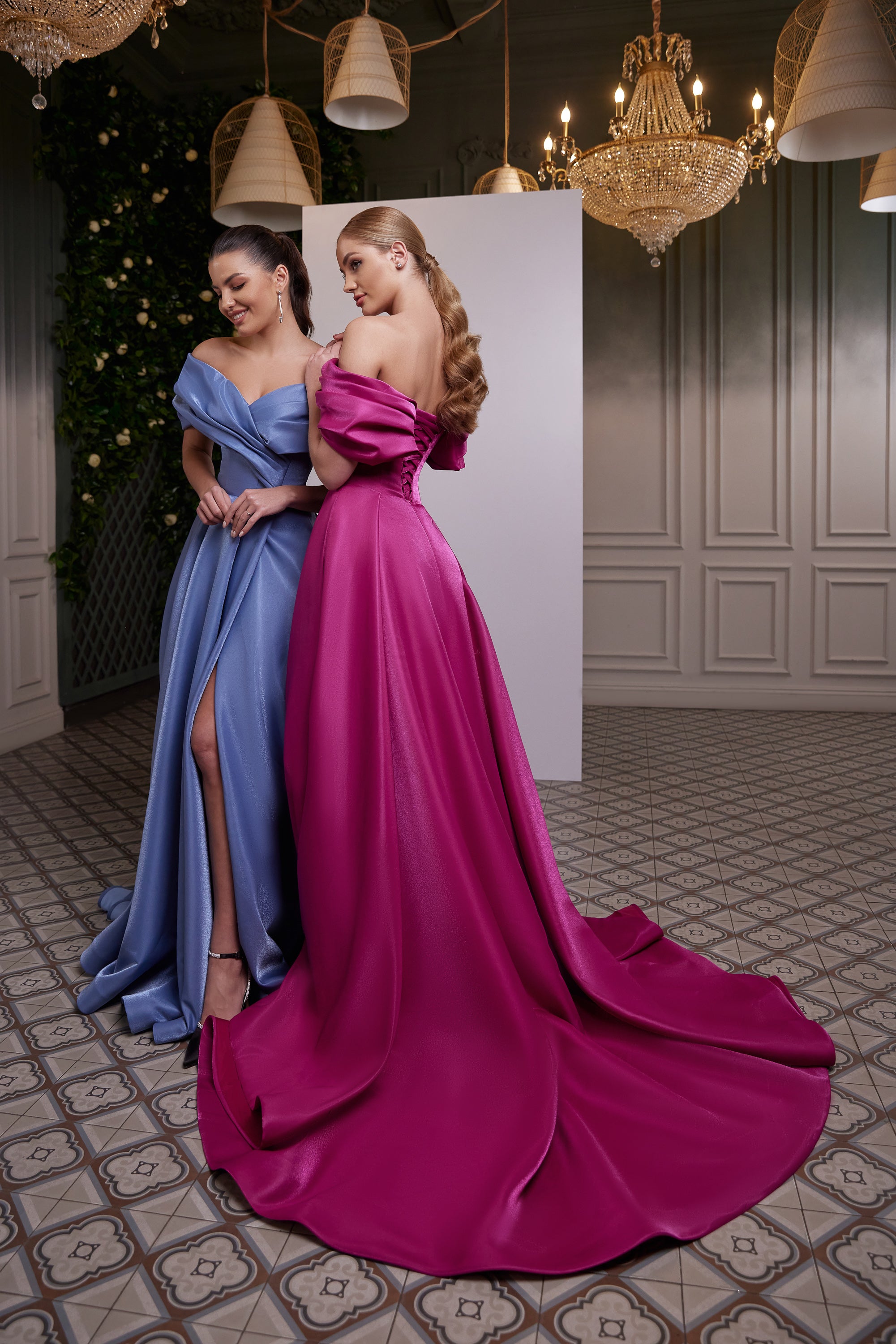 Magenta evening dress shown from the back with an off-shoulder draped neckline and sweeping floor-length train