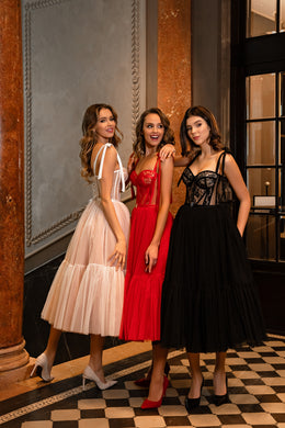 Red evening dress featuring a structured lace bodice, narrow straps, and a gathered midi skirt