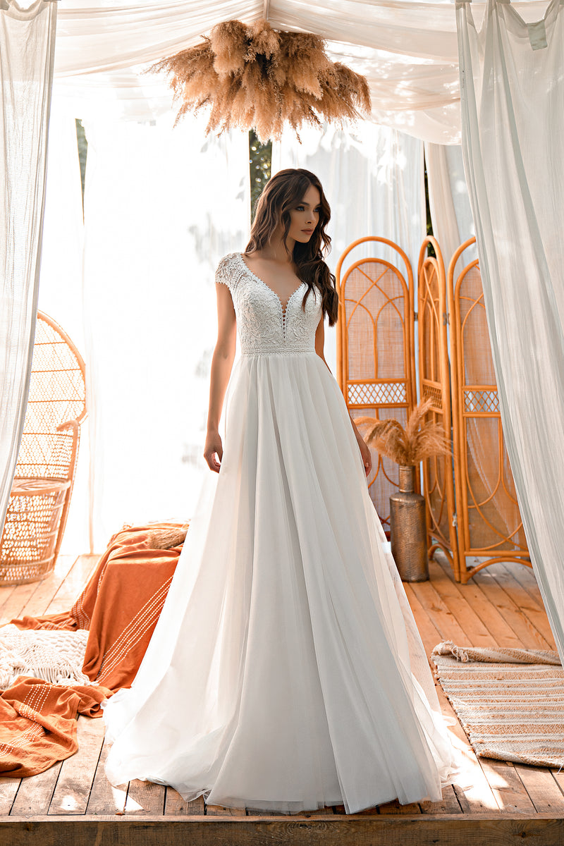 Ivory A-line wedding dress with a V-neck lace bodice, short sleeves, and a flowing full skirt