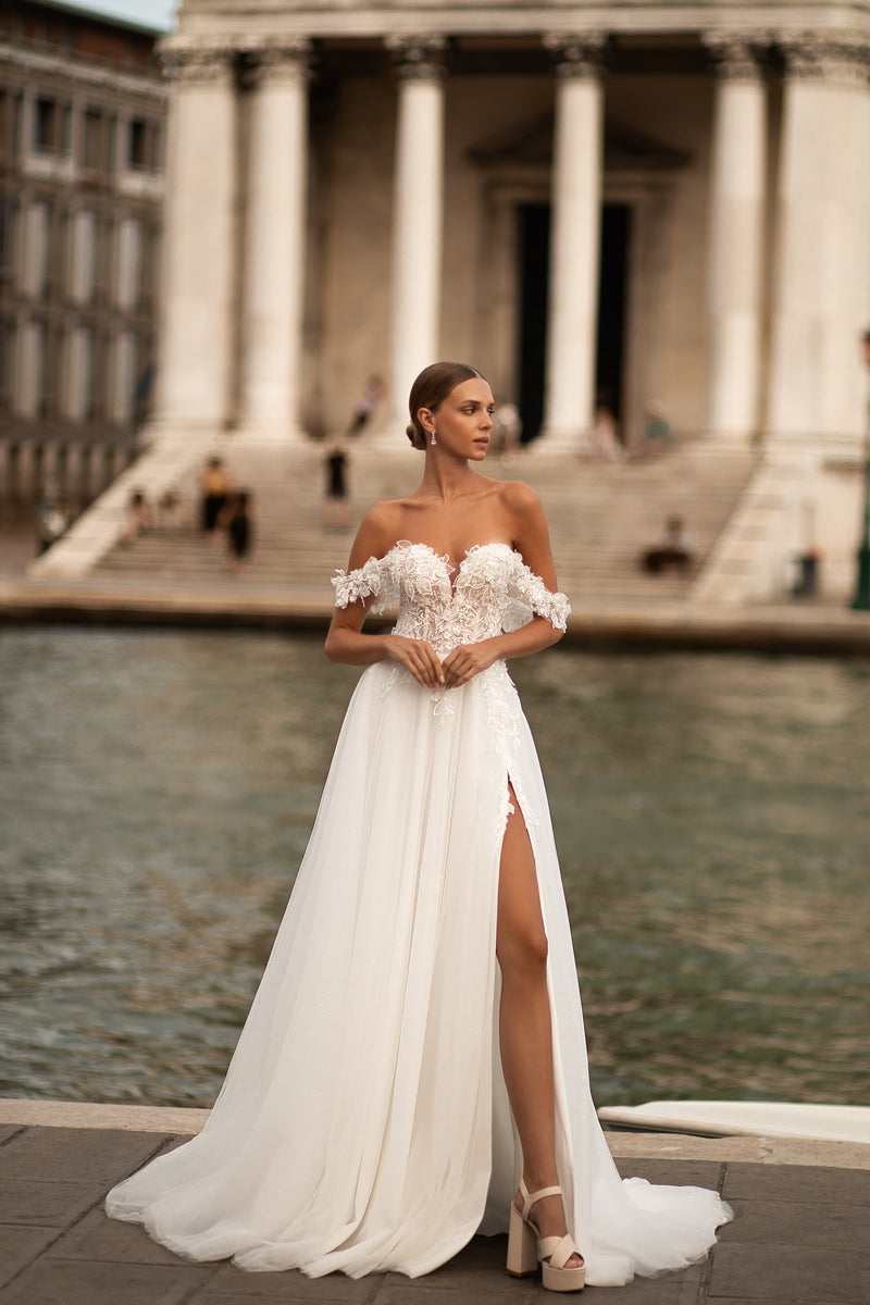 Ivory A-line wedding dress with off-the-shoulder floral lace bodice, thigh-high slit, and sweeping train