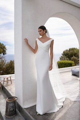 Ivory sheath wedding dress with draped V-neckline, fitted bodice, and floor-length hem