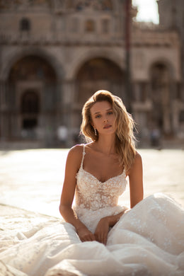 Close-up of the sweetheart neckline and embellished floral lace bodice on an ivory wedding dress