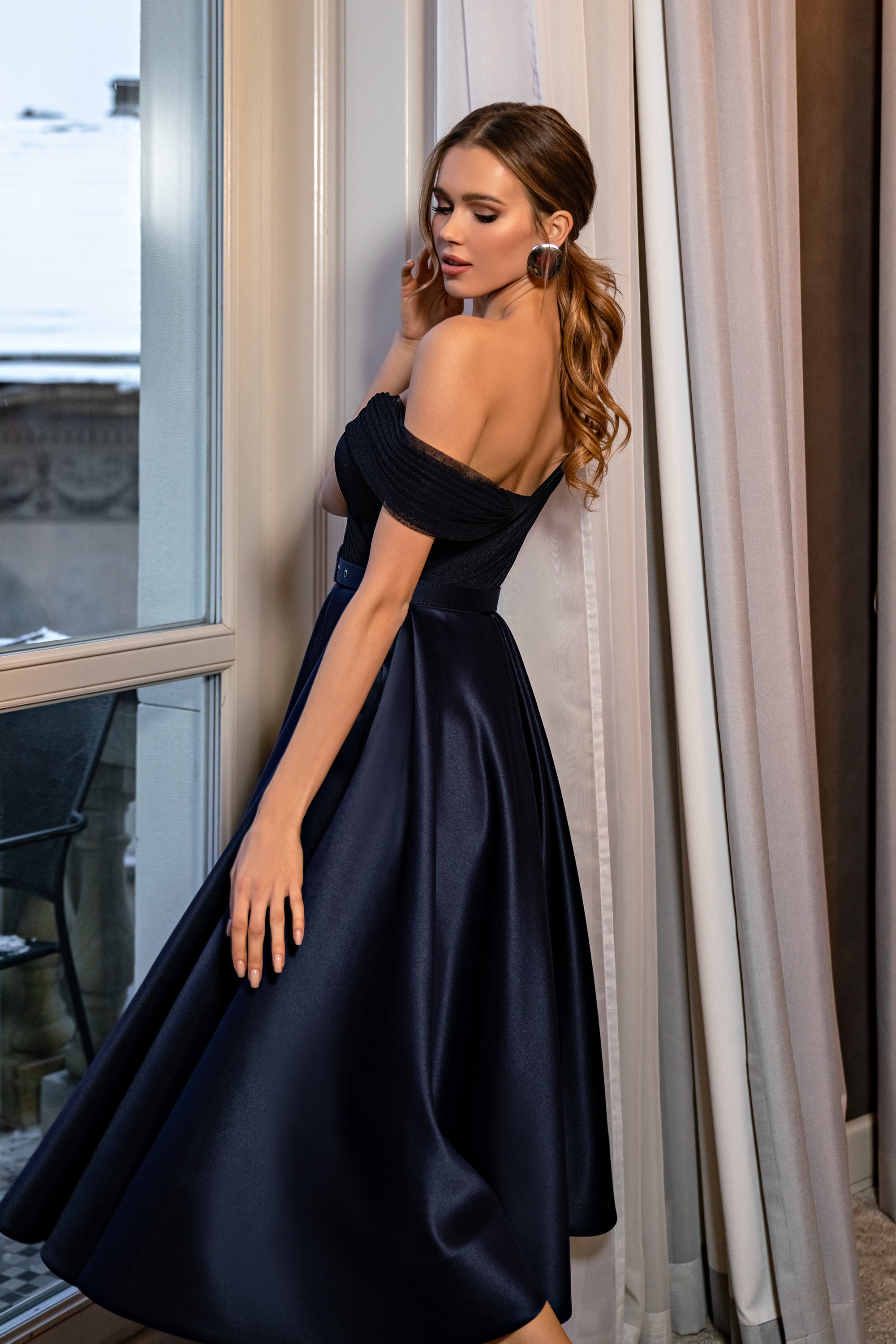 Black satin evening dress with an off-the-shoulder neckline, exposed back, and full midi skirt