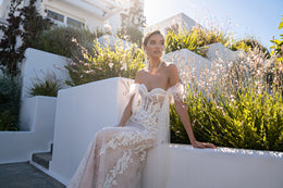 Floral lace wedding dress with a sweetheart neckline, sheer off-shoulder sleeves, and fitted mermaid silhouette