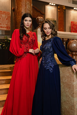 Red and navy evening dresses with long voluminous sleeves, embellished bodices, and flowing skirts