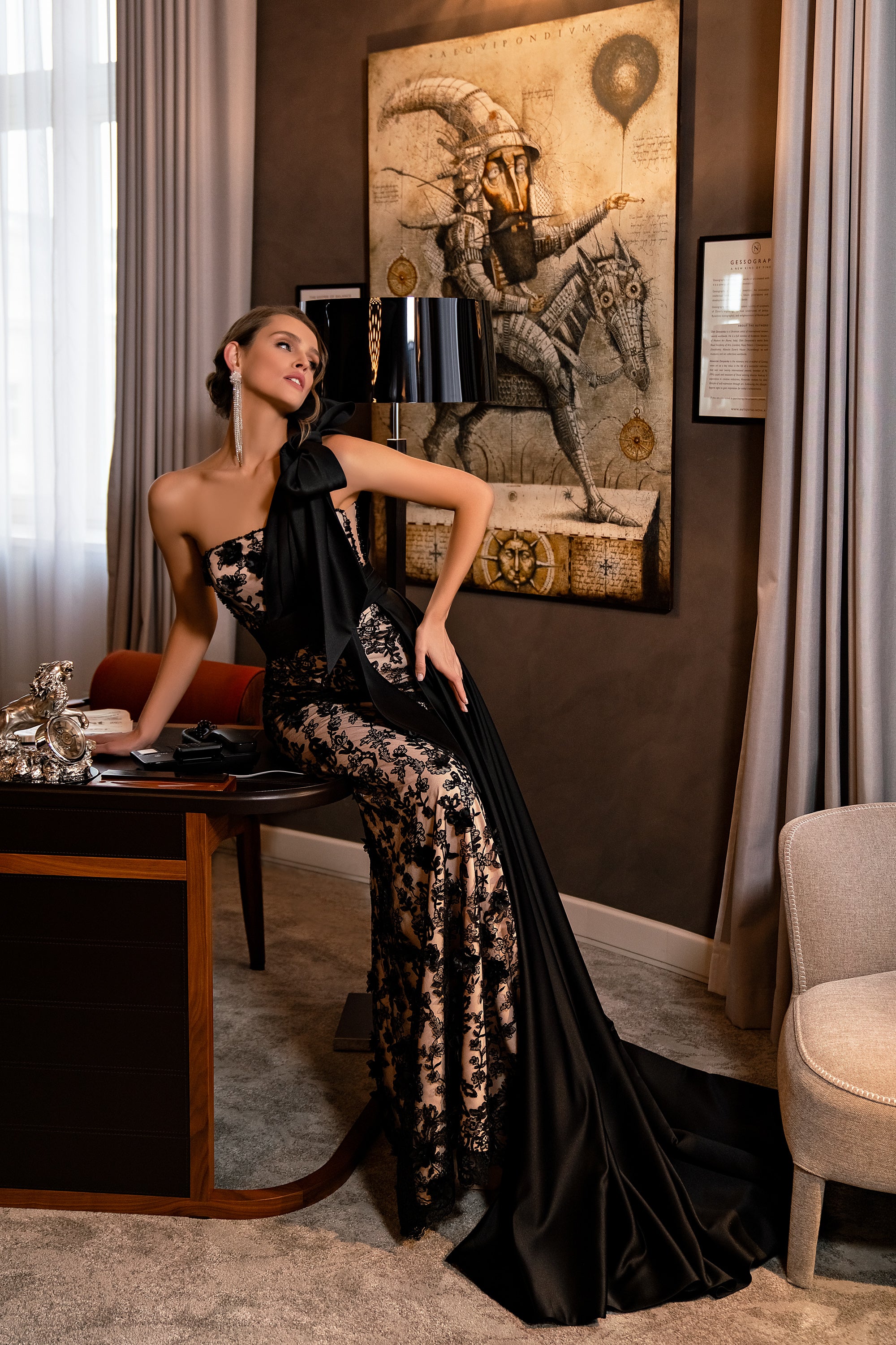 Black evening dress with floral lace, an asymmetrical shoulder detail, and a long satin train