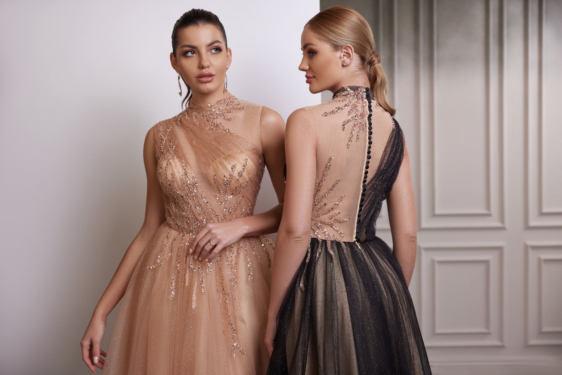 Black evening dress with an asymmetrical sheer back, button closure, and glittering A-line tulle skirt