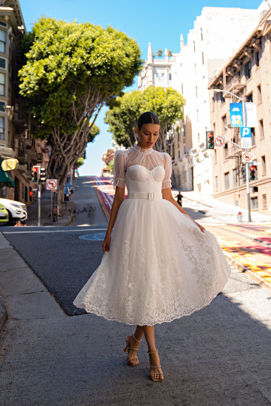 Ivory A-line wedding dress with sheer lace neckline, short sleeves, belted waist, and floral lace skirt