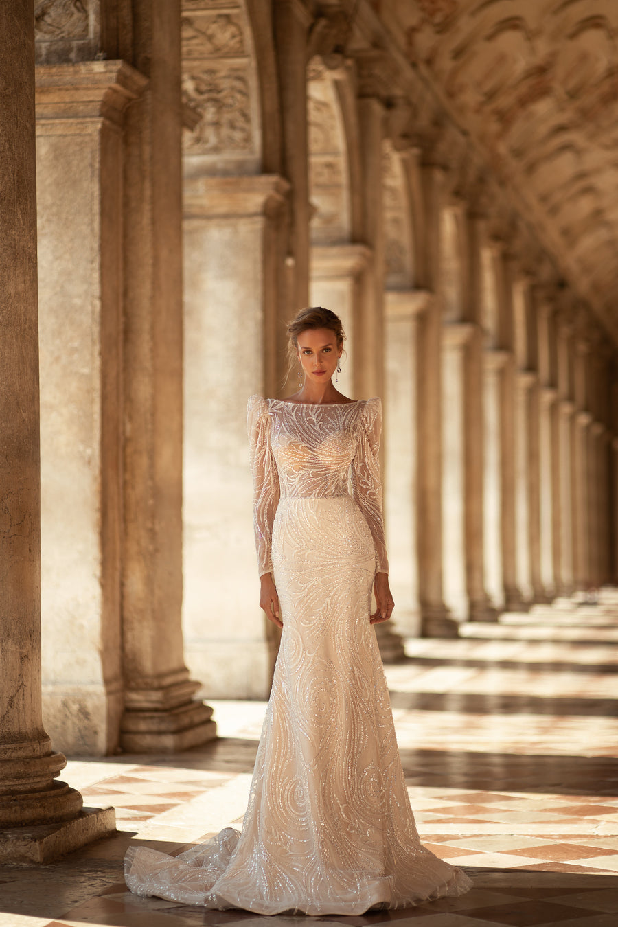 Ivory wedding dress with a high neckline, long sleeves, fitted sequined bodice, and flared floor-length skirt