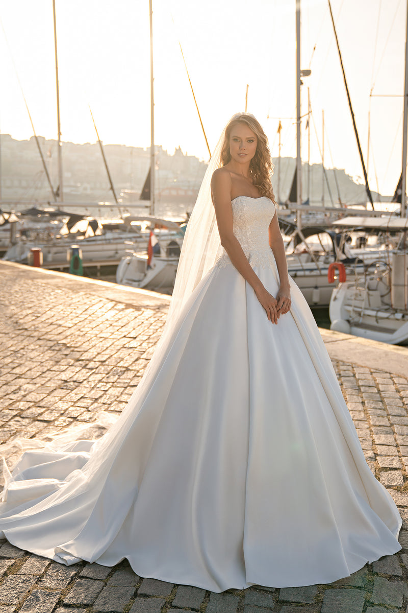 Ivory strapless ball gown wedding dress with a beaded bodice, full skirt, and sweeping train