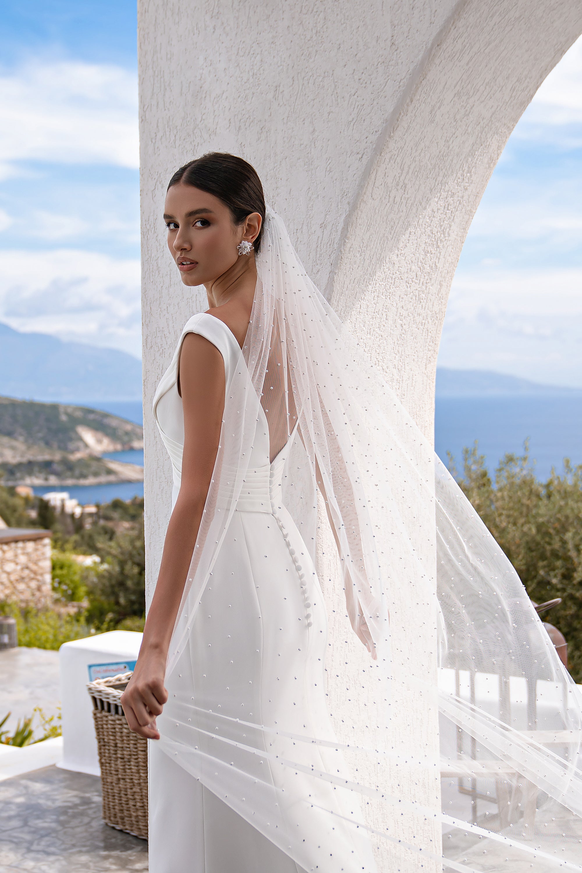Close-up of the low open back and slim shoulder straps on an ivory wedding dress