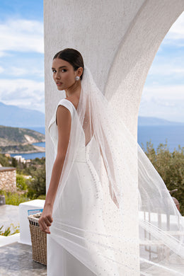 Close-up of the low open back and slim shoulder straps on an ivory wedding dress