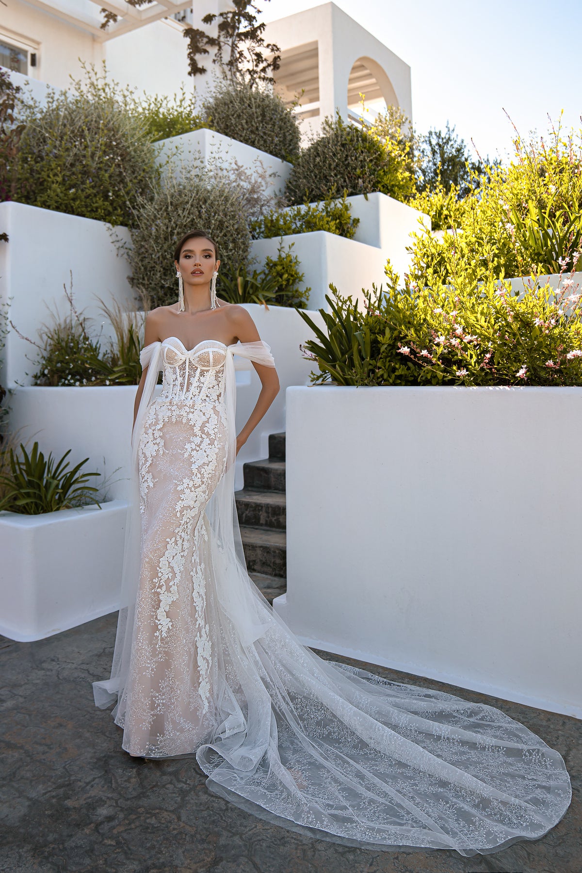 Ivory mermaid wedding dress featuring floral lace, off-shoulder tulle sleeves, and an extended train
