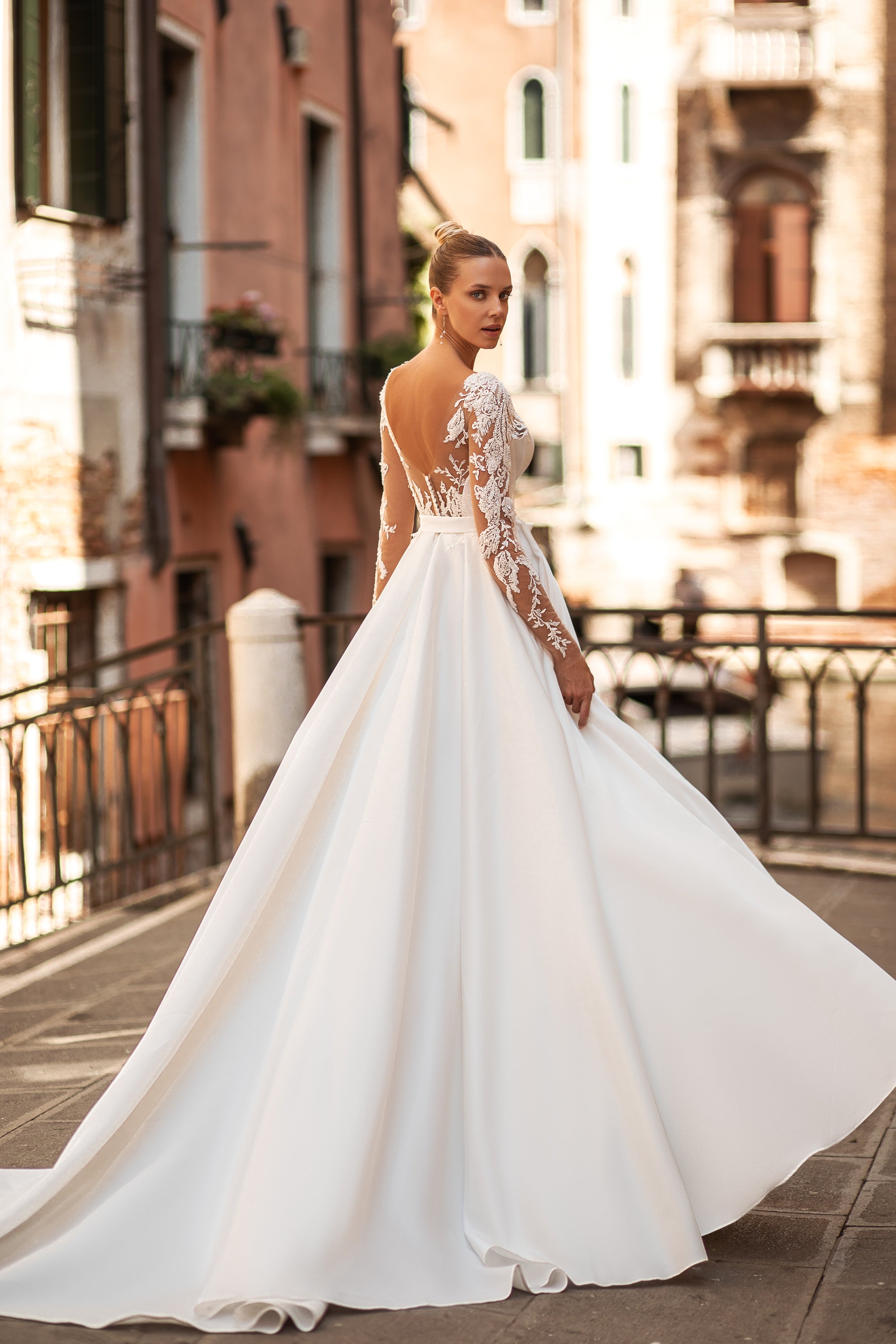Elegant A-Line Wedding Gown with Deep V-Neck, Low Back, Long Lace Sleeves, Bow at Waist, and Slit Skirt