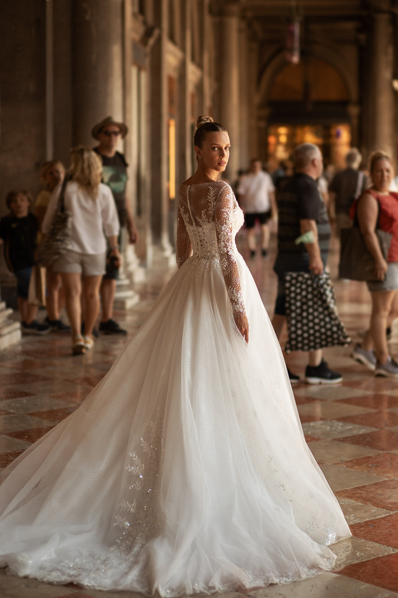 Sheer embellished back and long train on an ivory A-line wedding dress