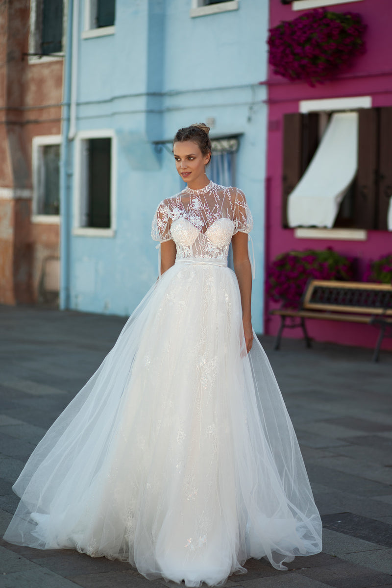 Ivory A-line wedding dress with beaded lace bodice, sheer short sleeves, and a full flowing skirt