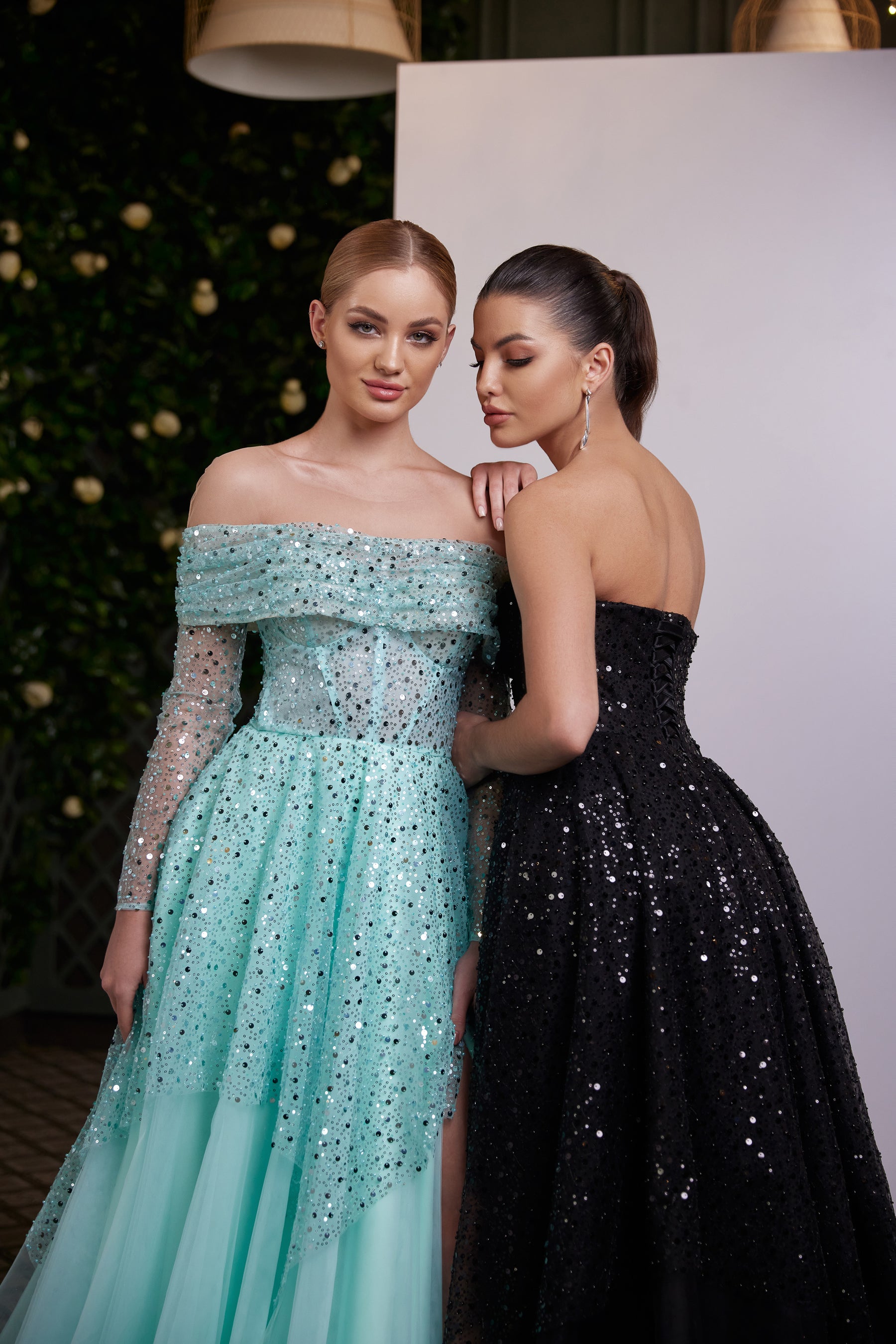 Back-facing black sequin evening dress with a strapless bodice, fitted waist, and full floor-length skirt