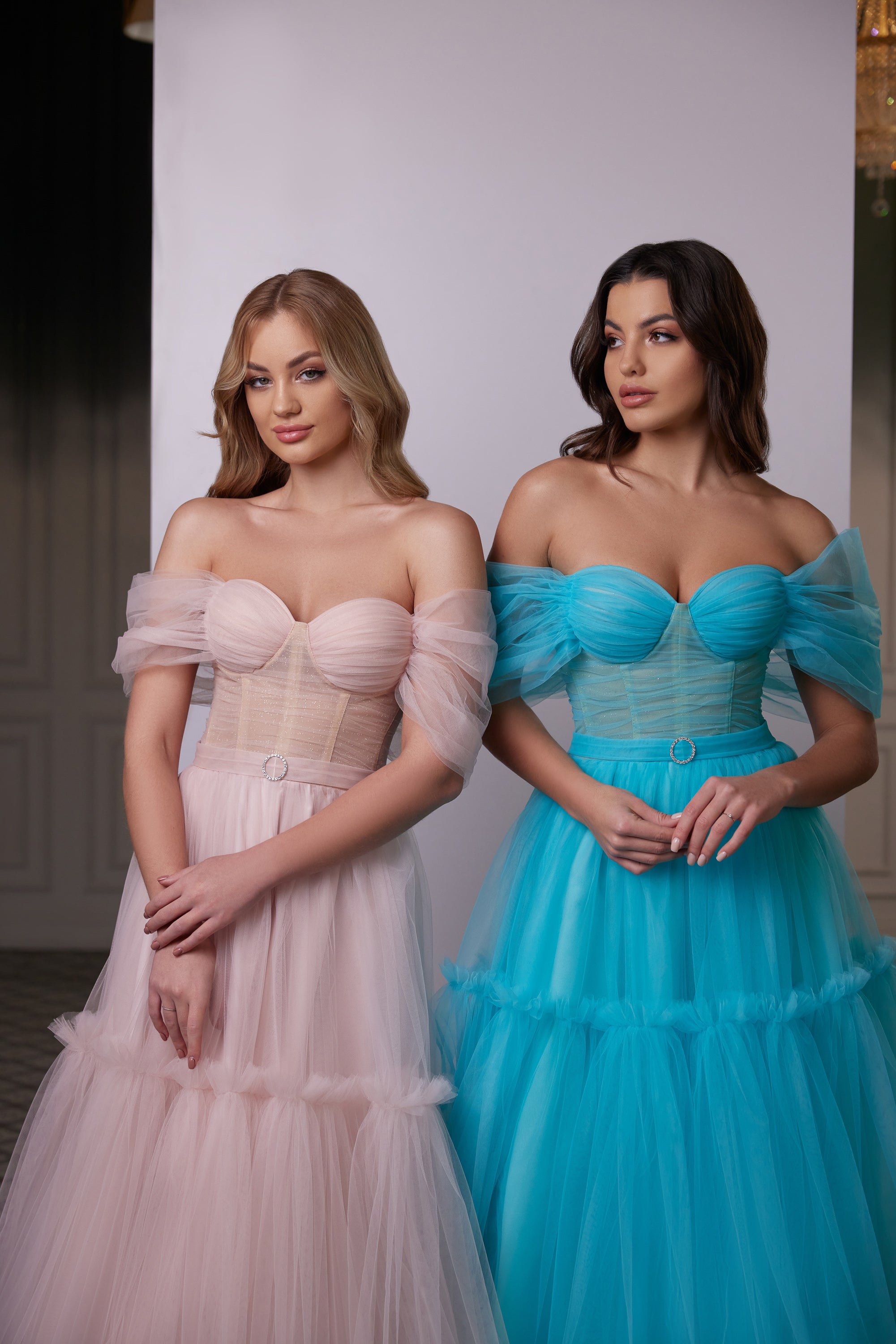 Close-up of a blush pink evening dress with a sweetheart bodice, sheer off-shoulder sleeves, and ruched waist