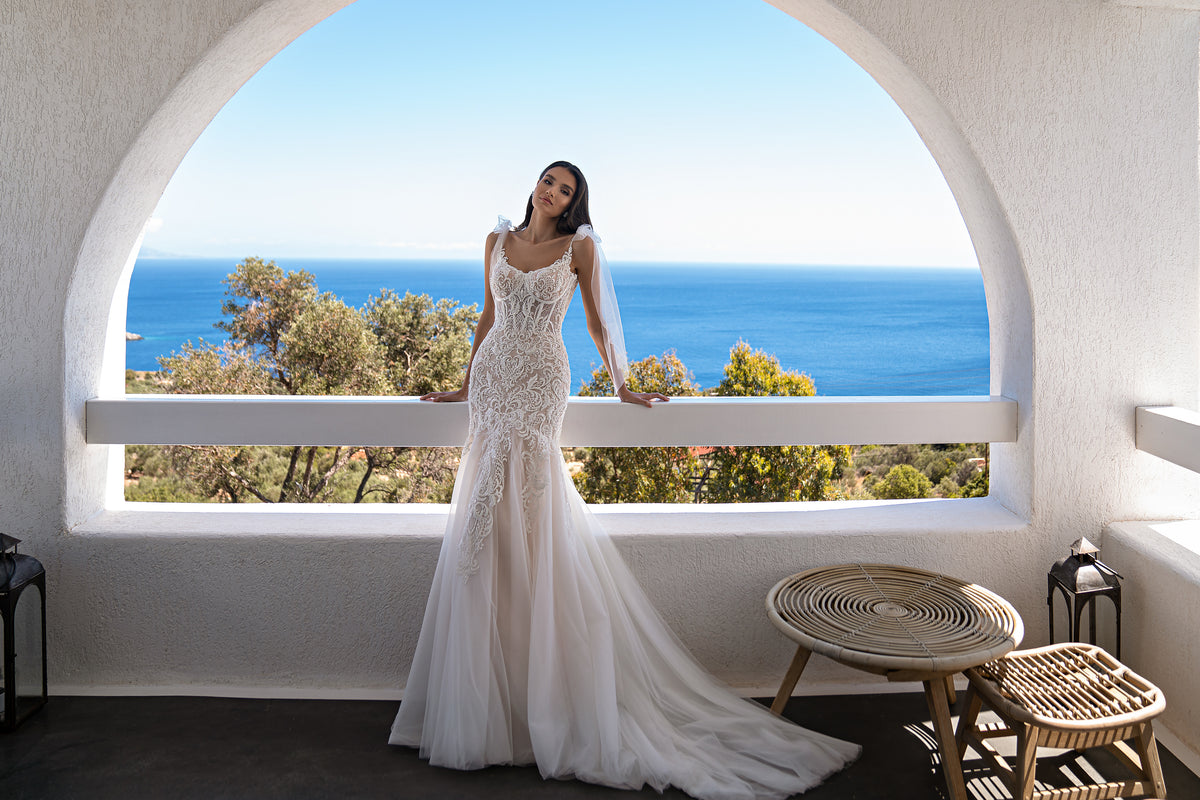 Ivory lace wedding dress with a fitted mermaid silhouette, sheer sleeves, and a sweeping floor-length train