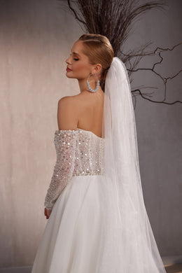 Sheer white wedding veil with fine sparkle cascading down the back to a long trailing hem
