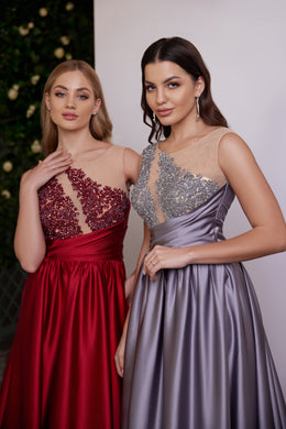 Red and lavender evening dress bodices with sheer mesh panels, asymmetrical beadwork, and gathered satin skirts
