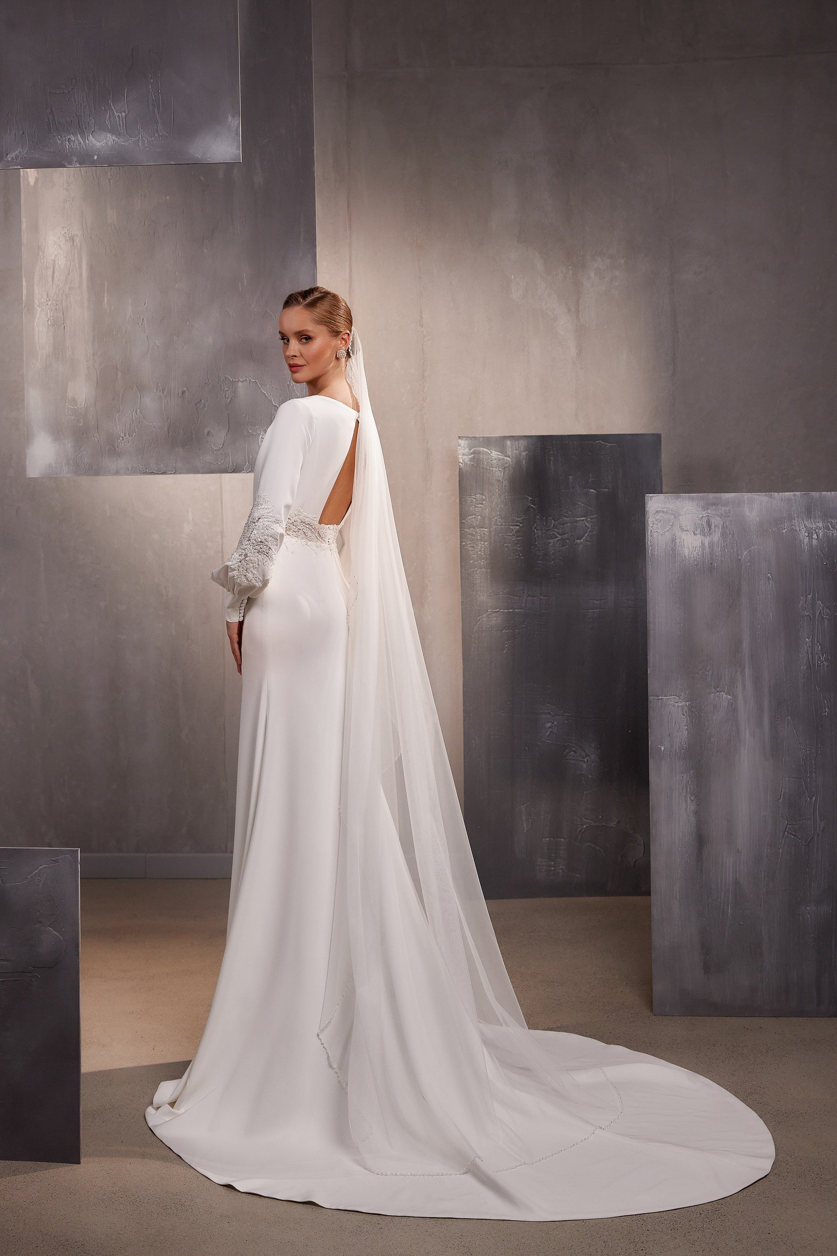 Long white wedding veil flowing from the head to the floor with a wide, rounded train
