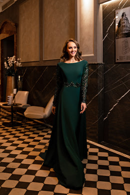 Emerald evening dress with a bateau neckline, long embellished sleeves, beaded waist, and flowing A-line skirt