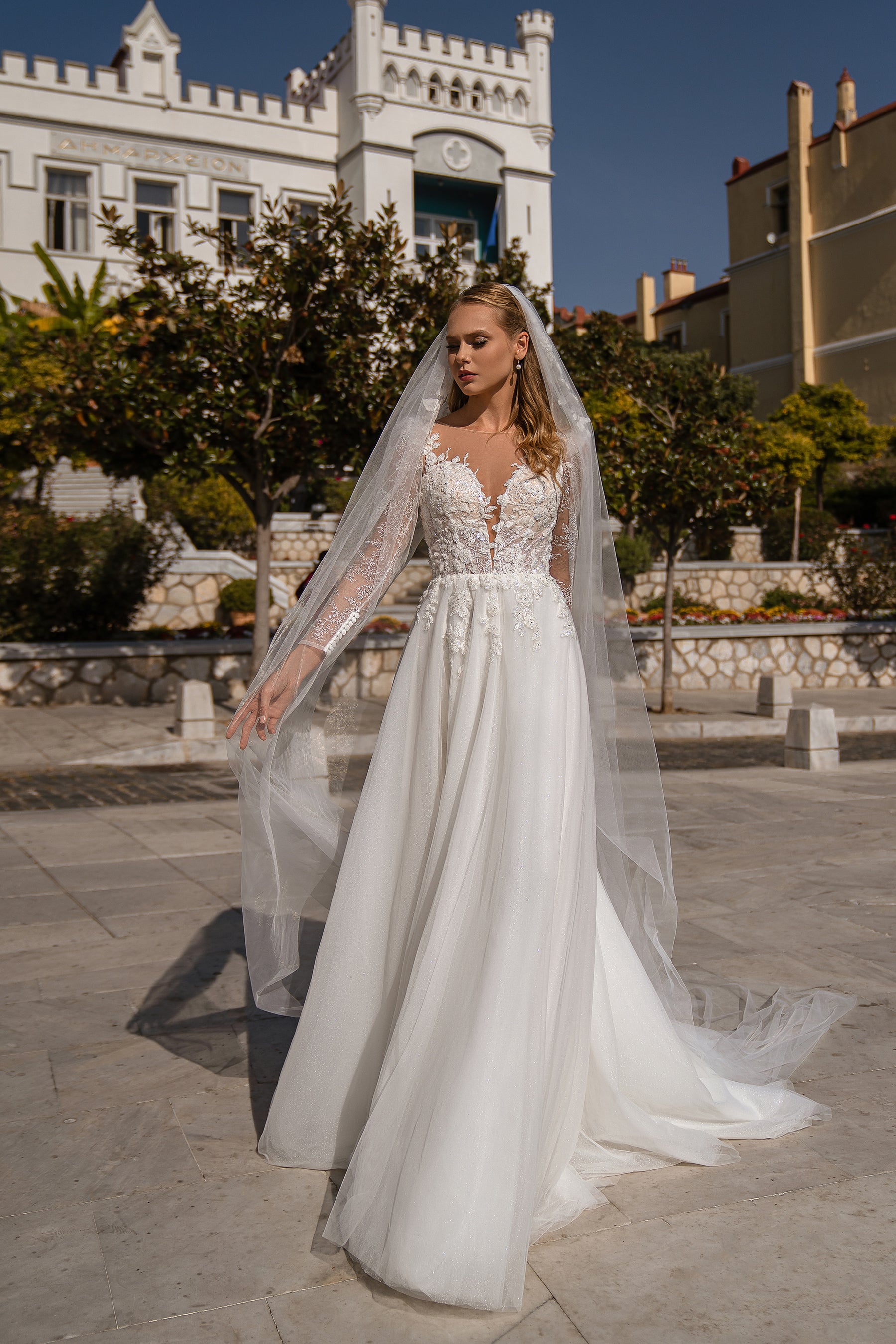 Long sheer wedding veil draping from the head to the ground over a beaded bridal gown