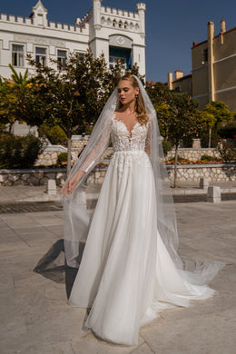 Long sheer wedding veil draping from the head to the ground over a beaded bridal gown