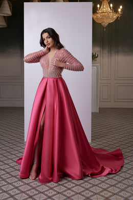 Pink satin evening dress with embellished long sleeves, a fitted bodice, front slit, and flowing train