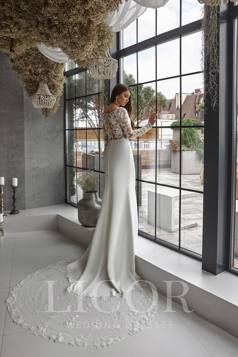 Ivory wedding dress with a fitted sheath silhouette and a long train edged in floral lace