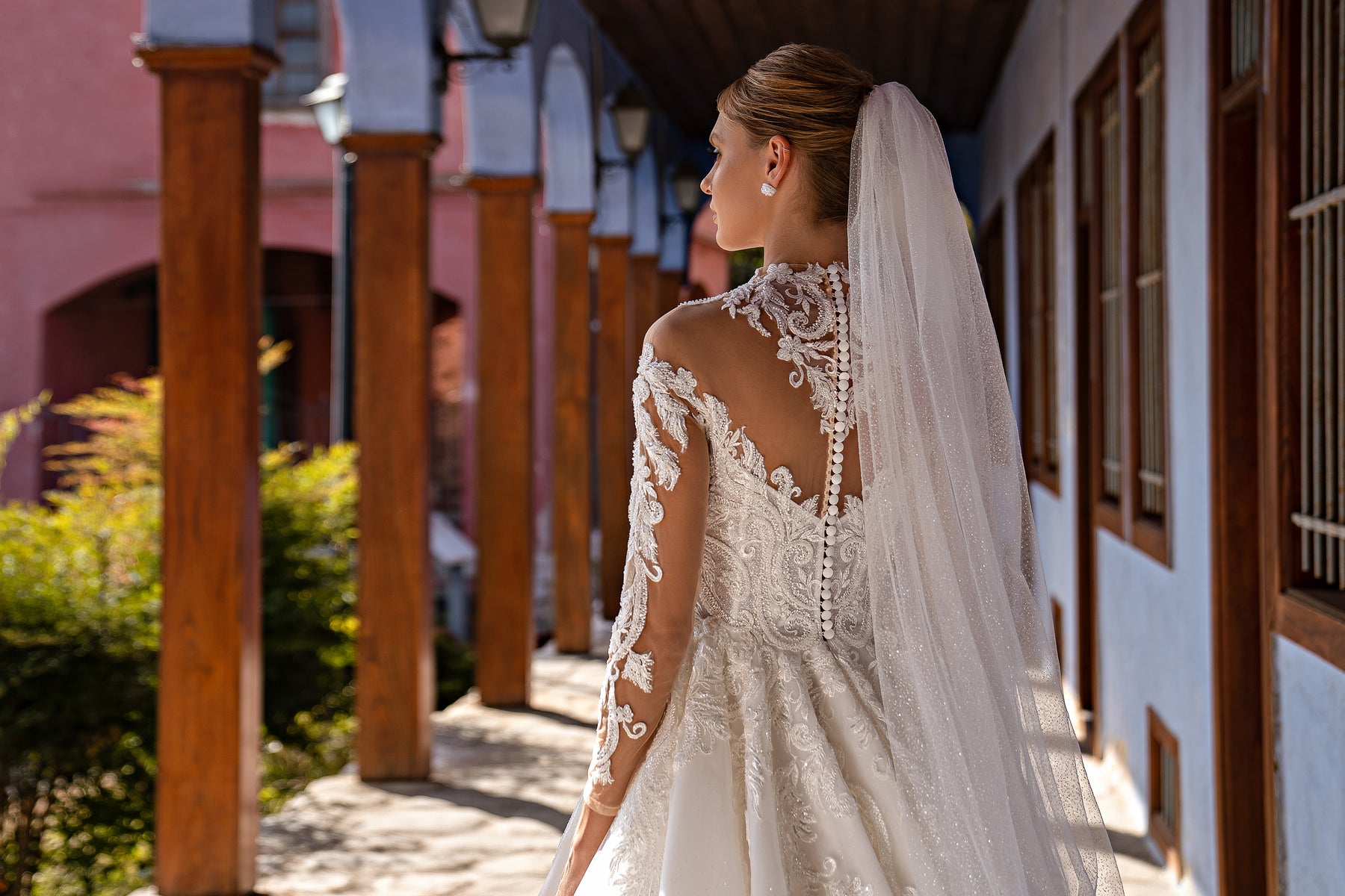 Sheer wedding veil cascading down the back with a delicate lace-trimmed edge and scattered sparkle