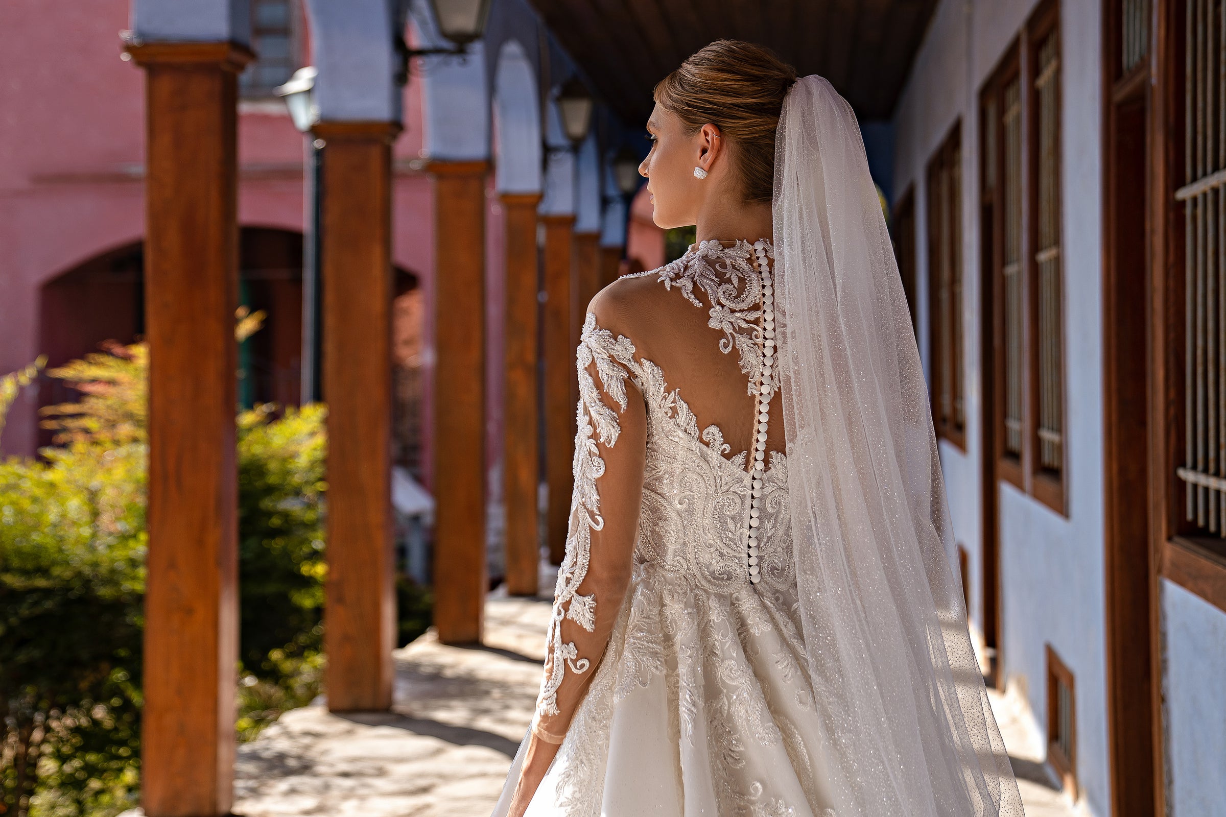 Sheer wedding veil cascading down the back with a delicate lace-trimmed edge and scattered sparkle